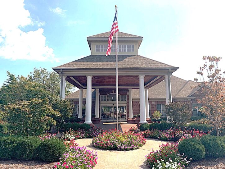 Front entrance with flag and flowers